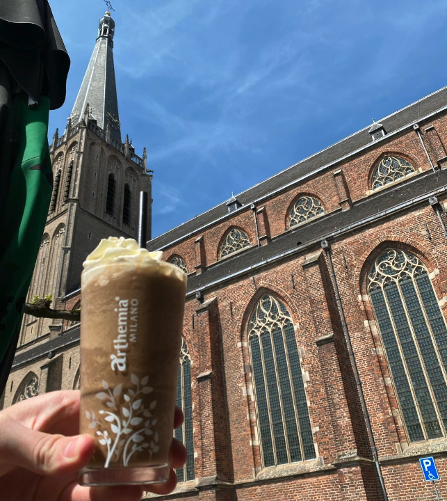 een ijskoffie voor de toren van de martinikerk in doesburg, aanzicht vanaf het terras van brasserie de poort